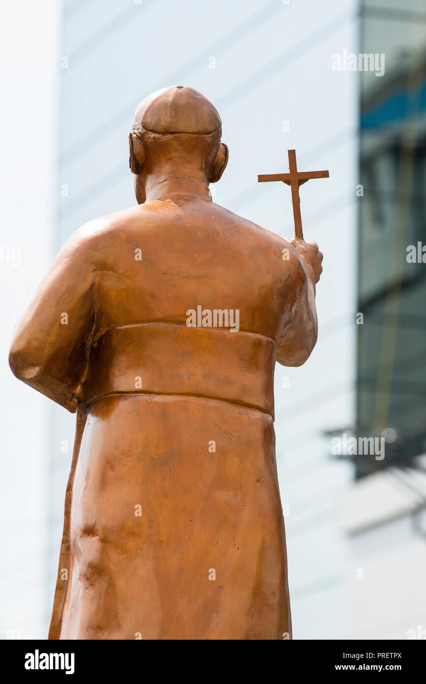 A golden statue of martyred Archbishop Oscar Romero stands against a ...