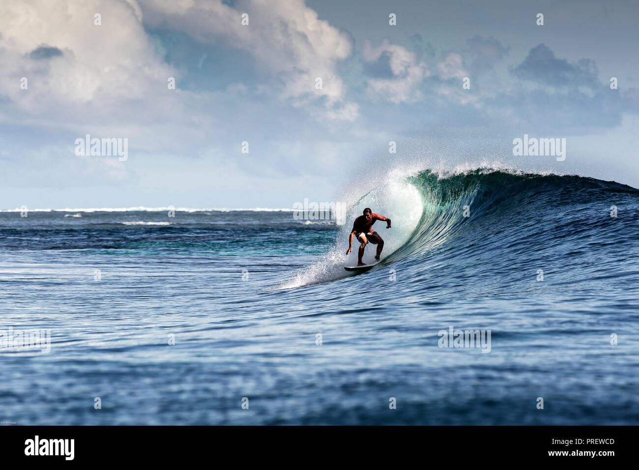 Surfing a blue reef wave in the Maluku islands, Indonesia Stock Photo