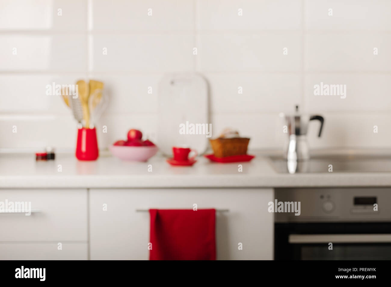 Blurred background interior white kitchen with kitchen tools and red  crockery. Selective focus Stock Photo - Alamy