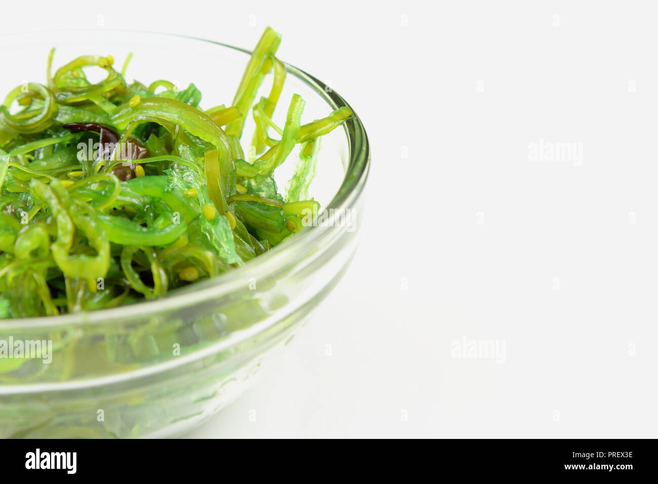 wakame salad with sesame in a small glass bowl isolated on a white background Stock Photo
