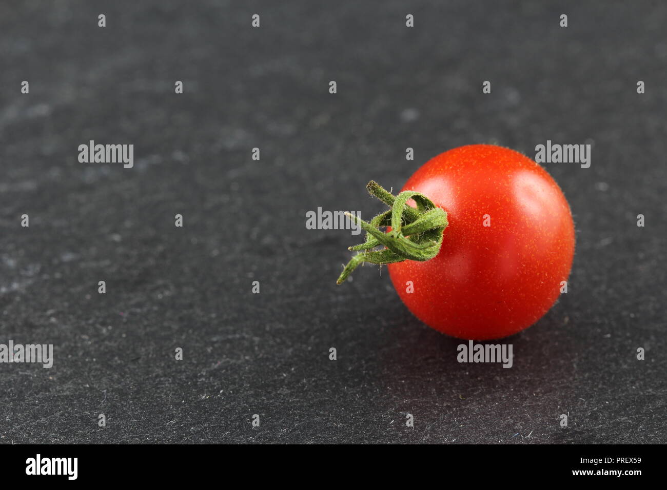fresh wild currant tomato isolated on a slate plate with copy space Stock Photo
