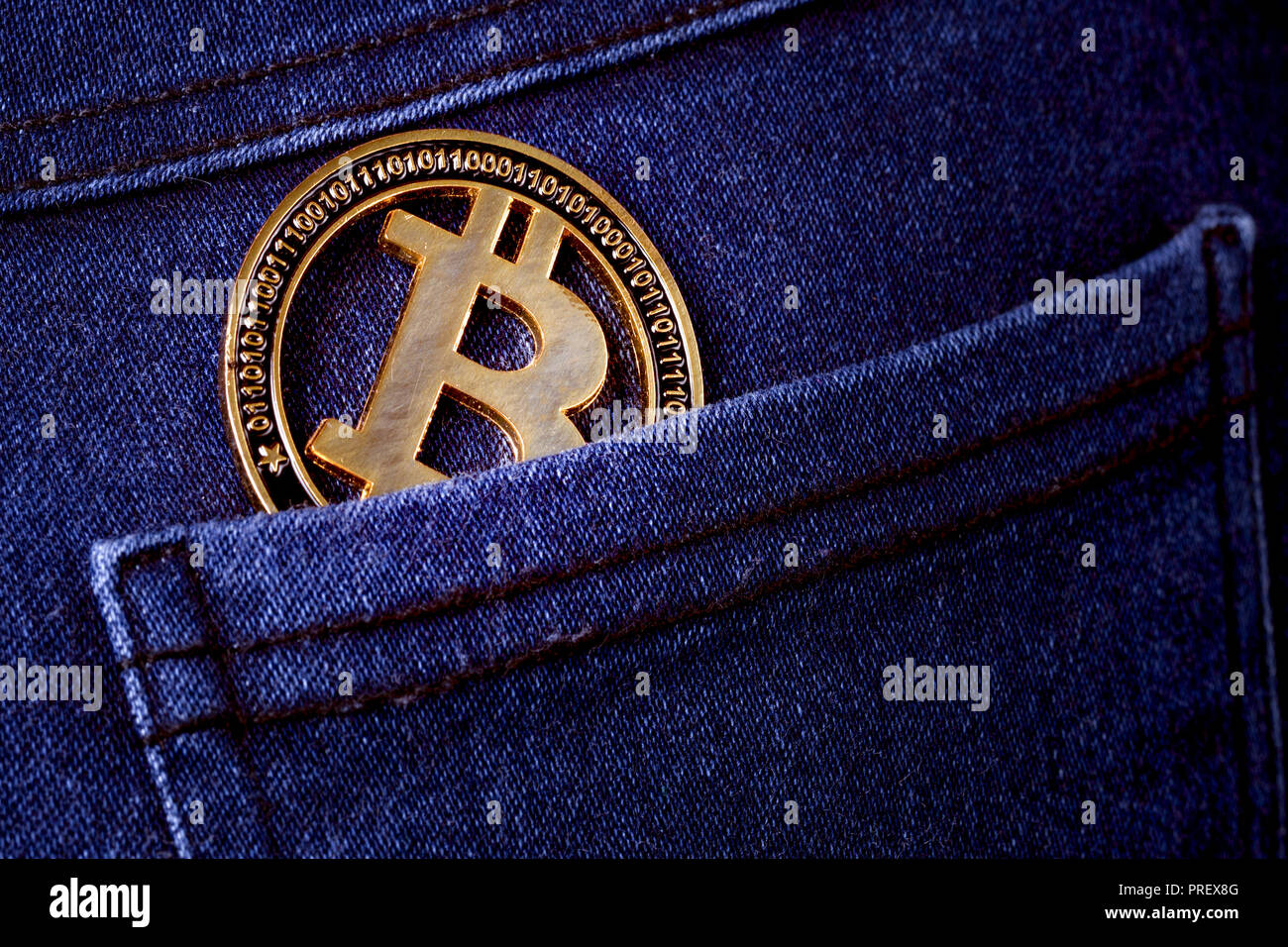 gold bitcoin in the back pocket of jeans, background image Stock Photo