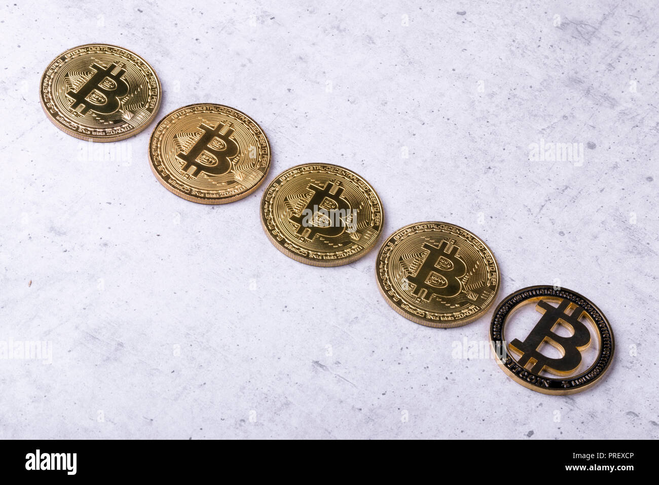 gold bitcoins on a concrete background, the concept of a falling crypto currency Stock Photo