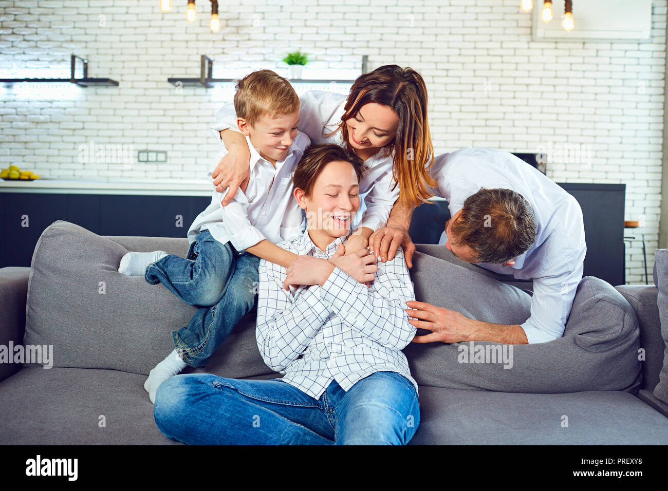 Happy family having fun playing together on a couch Stock Photo