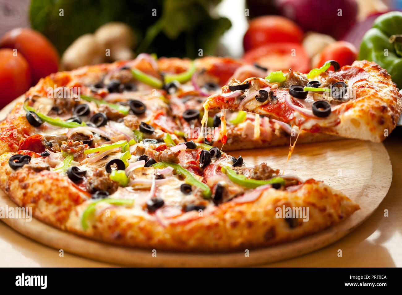 Hot Italian pizza slice with pepperoni and olives and mozzarella cheese drips. A piece of