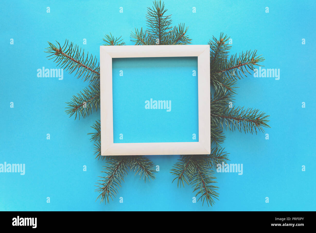 Christmas Border. Fir tree branches and white wooden frame on blue ...
