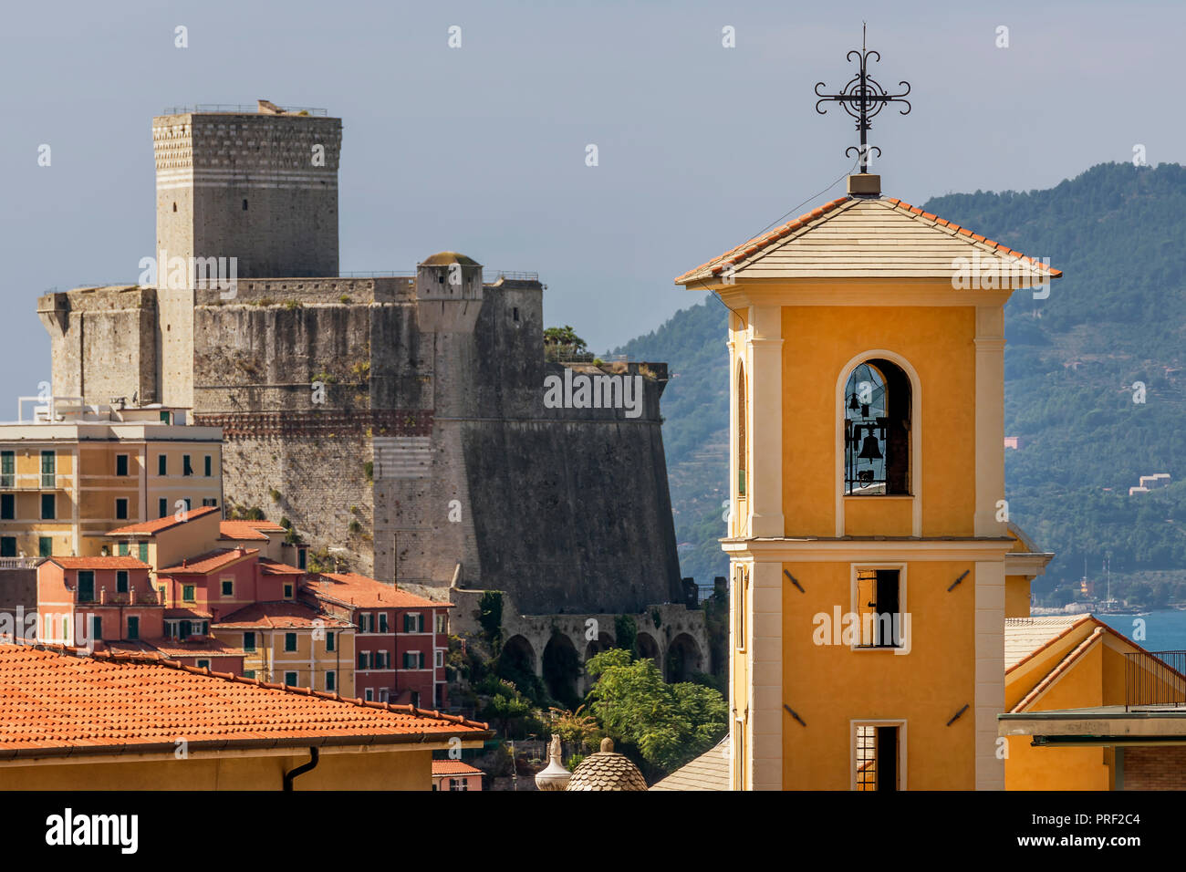View of the bell tower of the Church of San Francesco with the Castle of Lerici in the background, La Spezia, Liguria, Italy Stock Photo