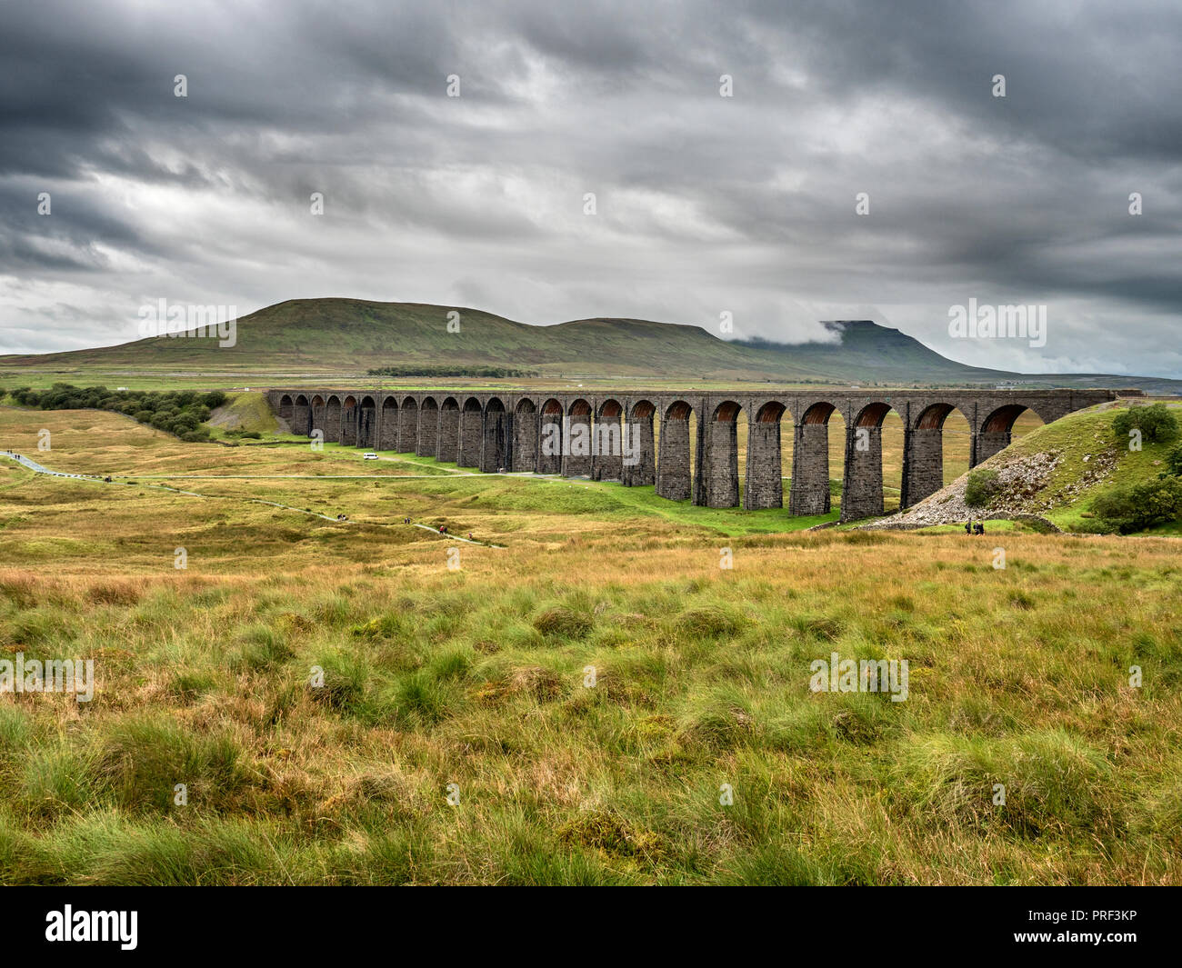 Low clouds loom over Ingleborough beyond the Ribblehead Viaduct Yorkshire Dales England Stock Photo