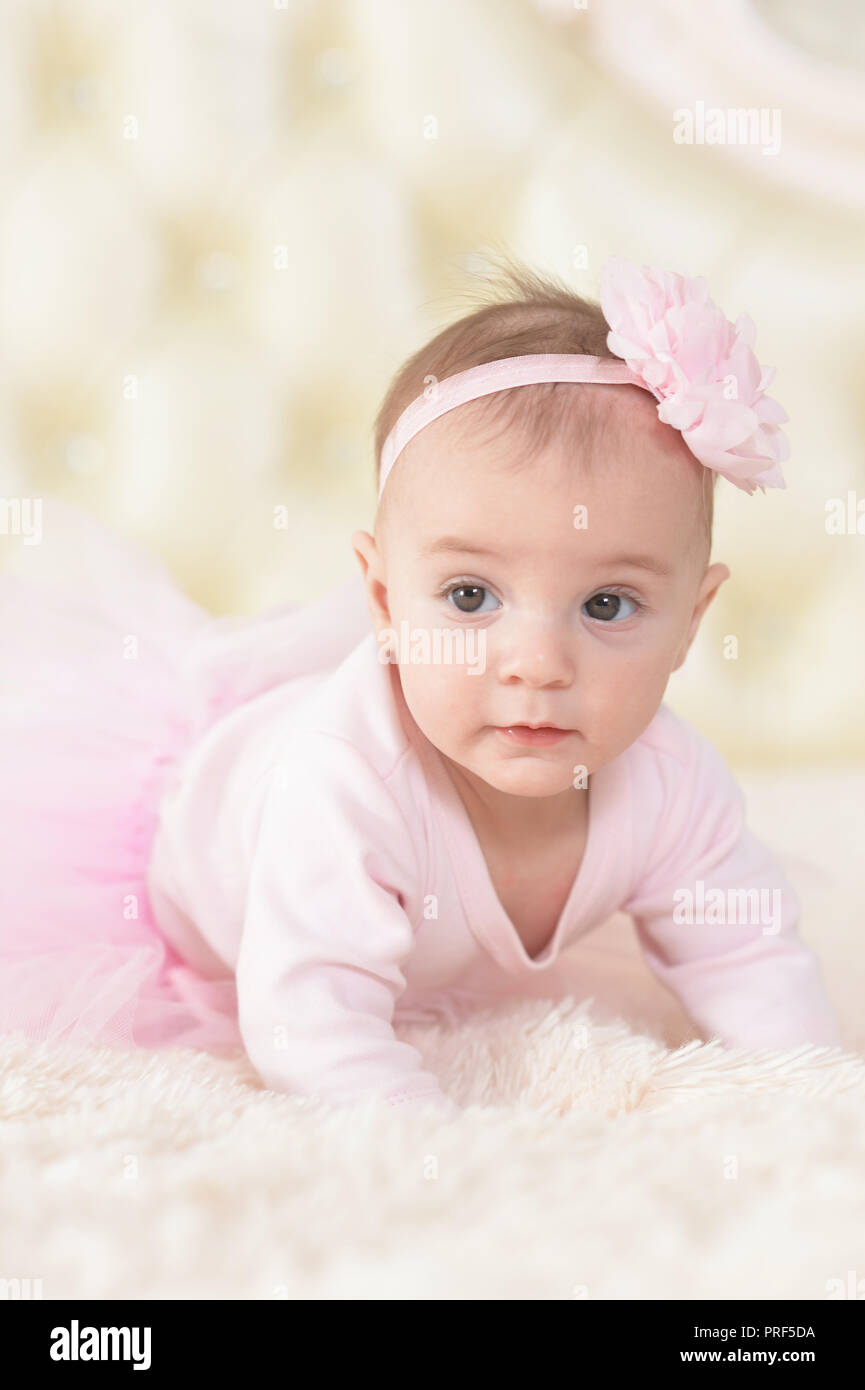 Cute charming girl in pink dress on bed at home Stock Photo - Alamy