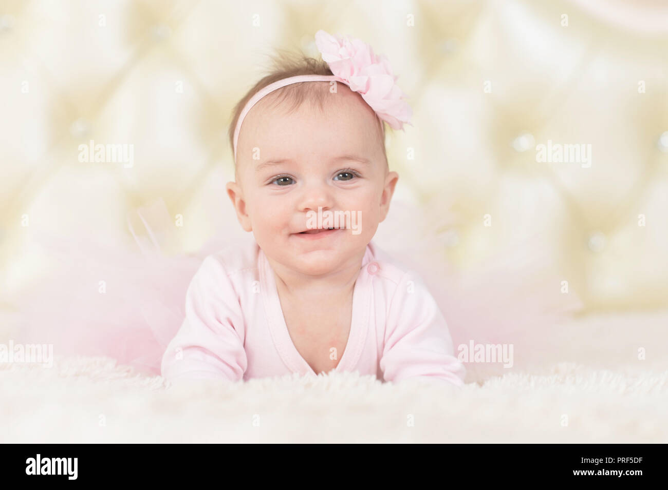 Cute charming girl in pink dress on bed at home Stock Photo - Alamy