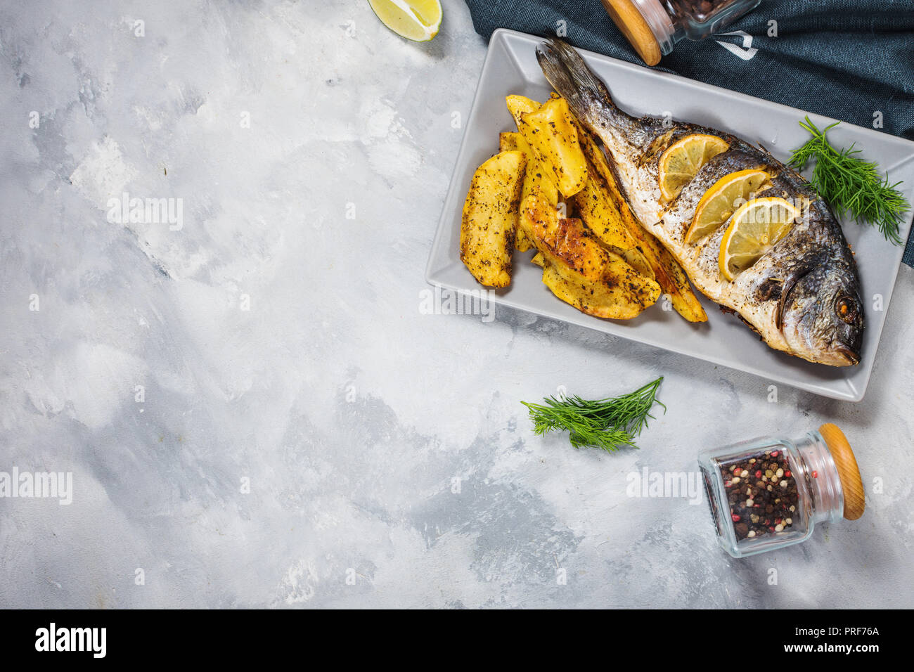 Grilled fish on stone plate with lemon Stock Photo
