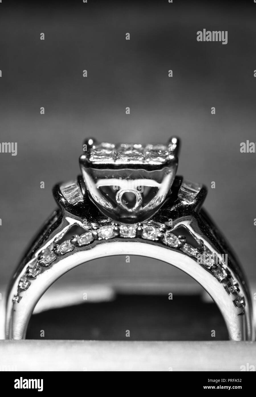 A diamond engagement ring in a box with glint/reflection. Shimmering princess-cut diamonds. Stock Photo