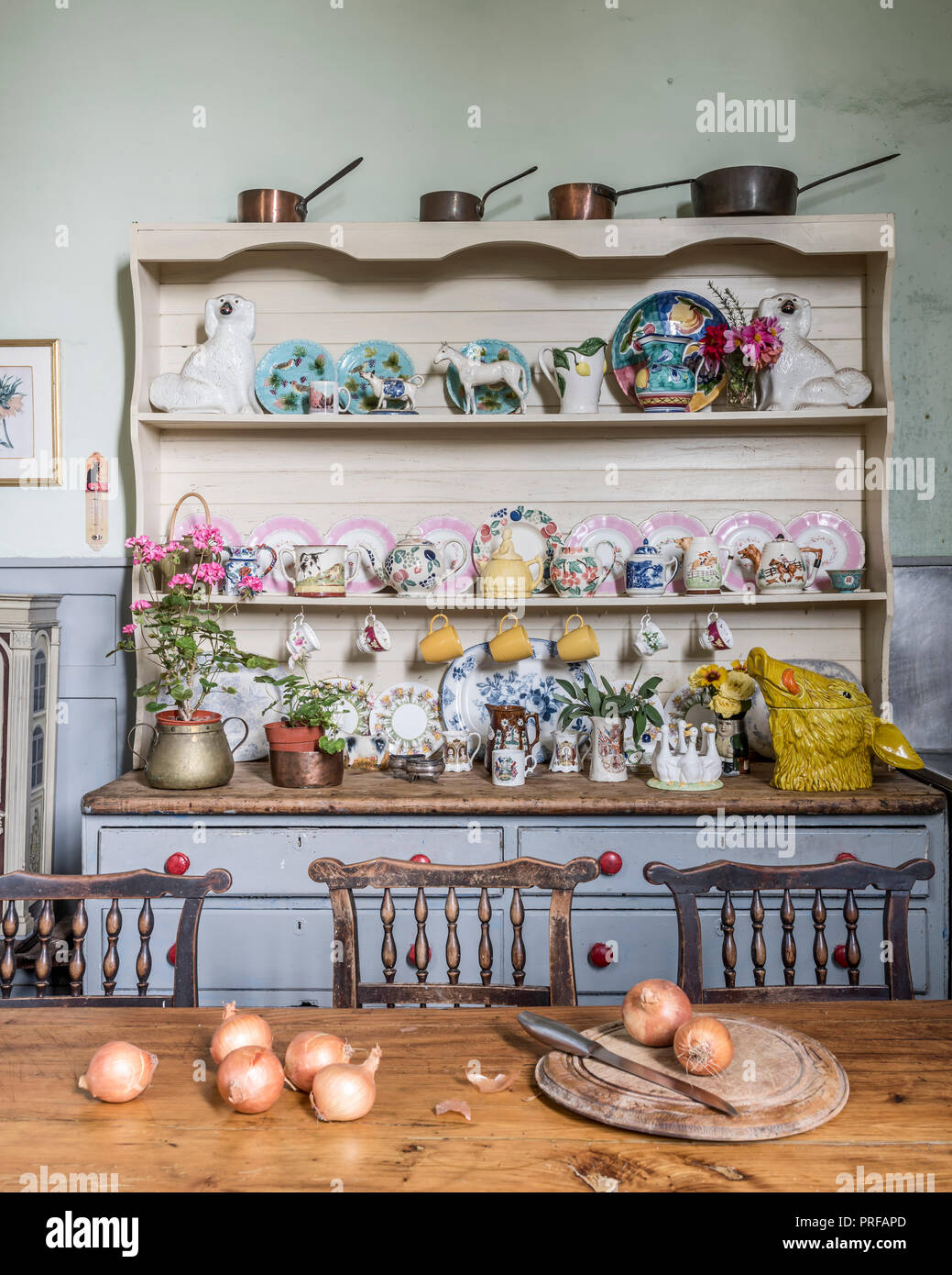 Collection of Staffordshire figures and teapots displayed on a painted dresser Stock Photo