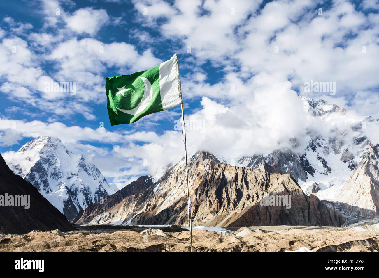 Pakistan flag in Concordia on Baltoro glacier, with K2 and Broad Peak mountains in the background, Karakoram, Pakistan Stock Photo