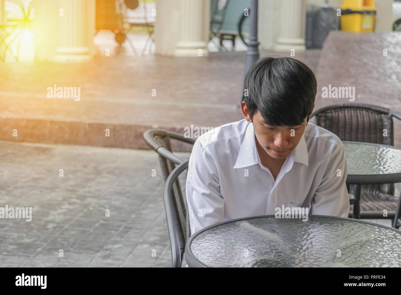 Young man handsome is bend down the head waiting in coffee shop with light Stock Photo - Alamy