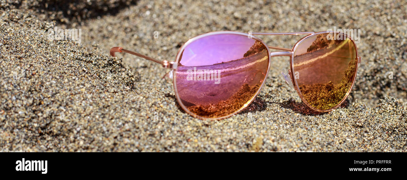 Sunglasses at the beach with sea reflection. Stock Photo