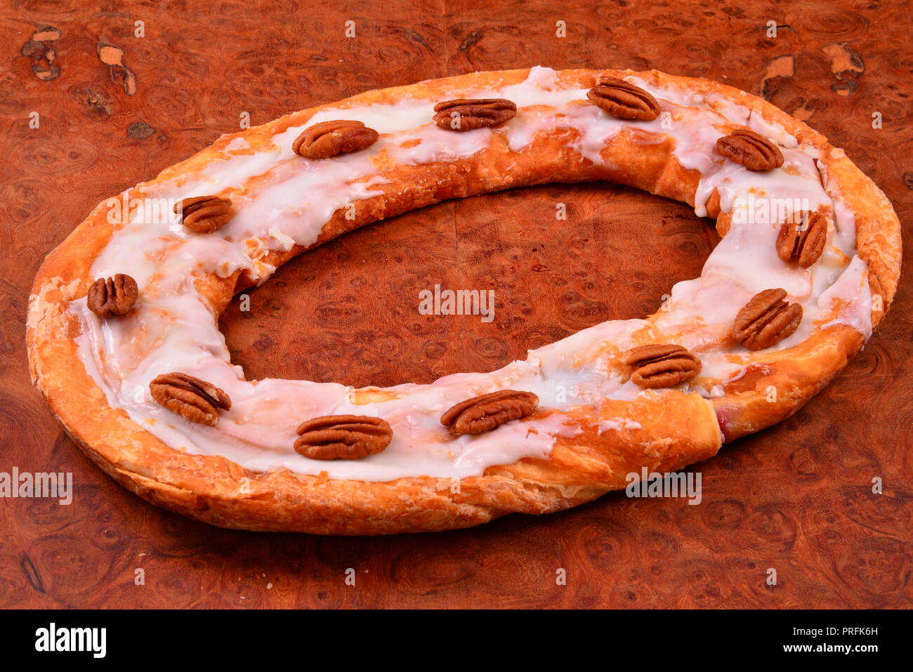 The sweet pastry treat pecan Kringle from Racine Wisconsin is a local favorite with a row of pecans. . Stock Photo