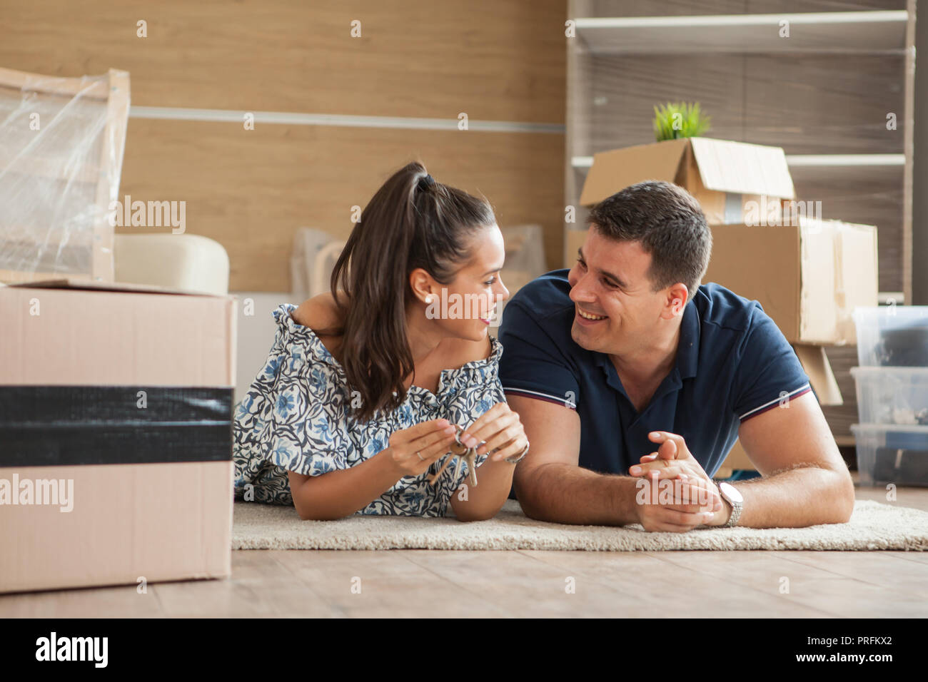 Couple showing keys of a new house.Moving in day Stock Photo - Alamy