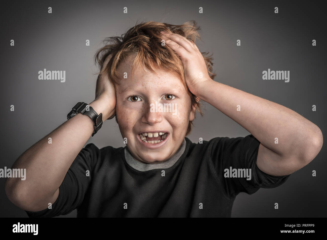 portrait of boy holding his head Stock Photo