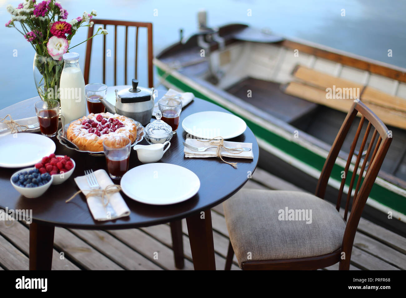 Luxury breakfast on the river. Table served with delicious homemade pie,  berries, tea and coffe on nature background Stock Photo - Alamy