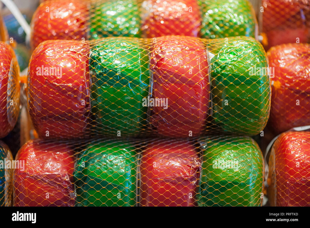 Net of green and red wheels of gouda cheese in a market in the Netherlands Stock Photo