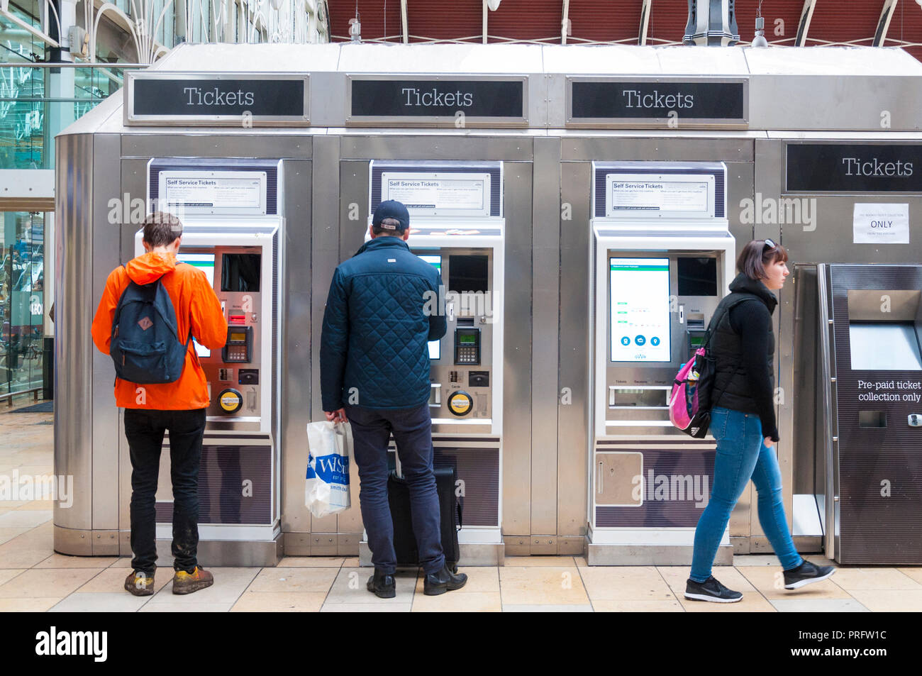 Paddington Railway Station, London, UK. Passengers buying tickets at machines on the concourse. Stock Photo