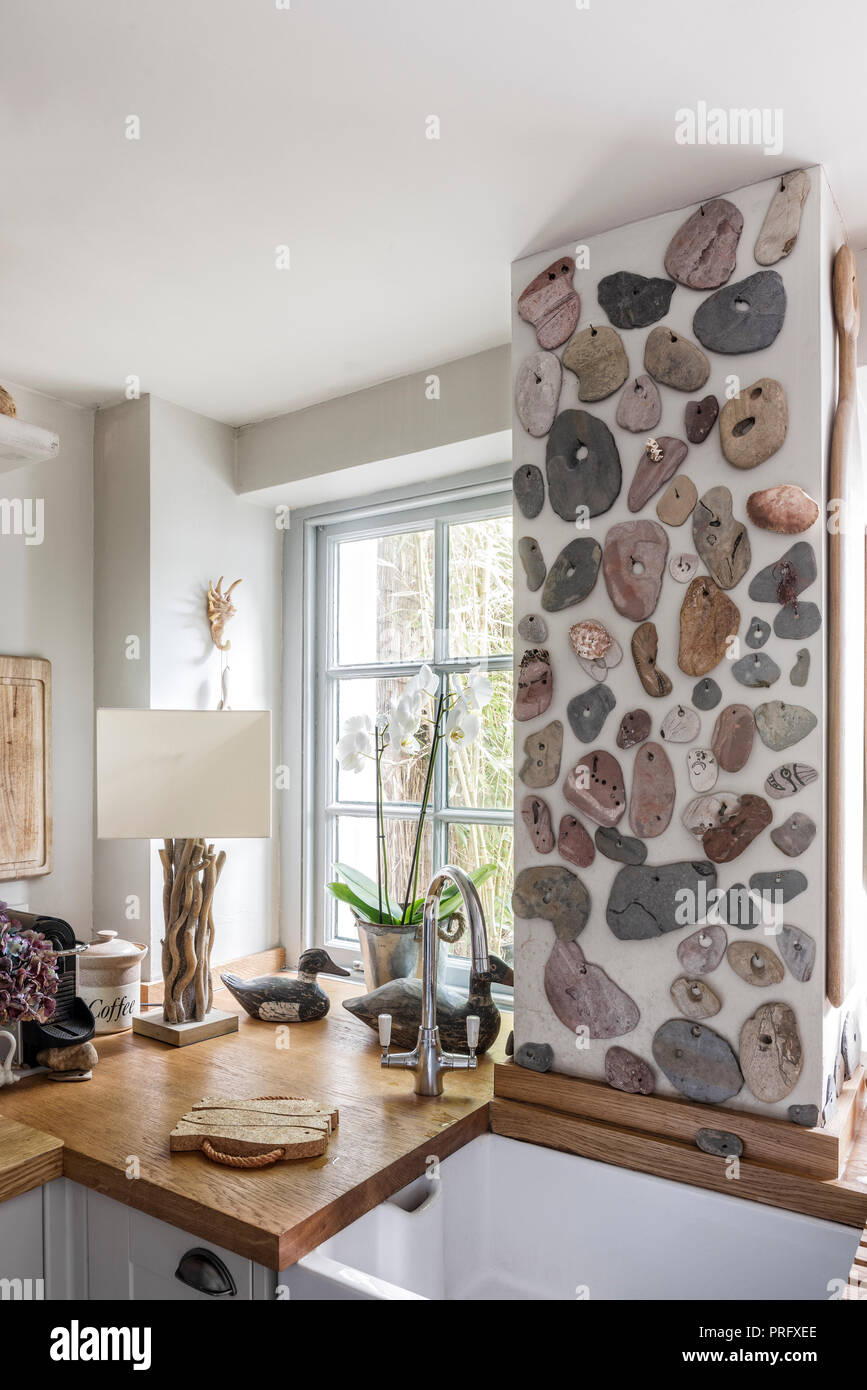 Collected stones as a wall feature in Devon kitchen Stock Photo