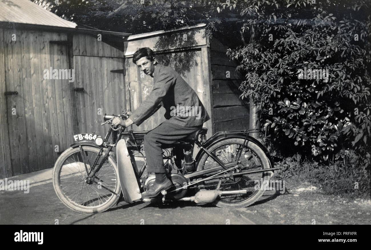 Young man on a 1923 New Imperial 250cc motorcycle in front of sheds in the 1920s Stock Photo