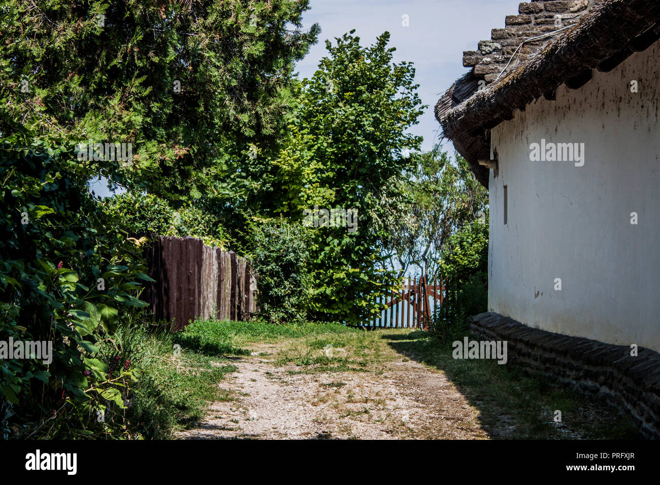 Traditional thatched roof building and lush green garden by the Lake Balaton, on Tihany