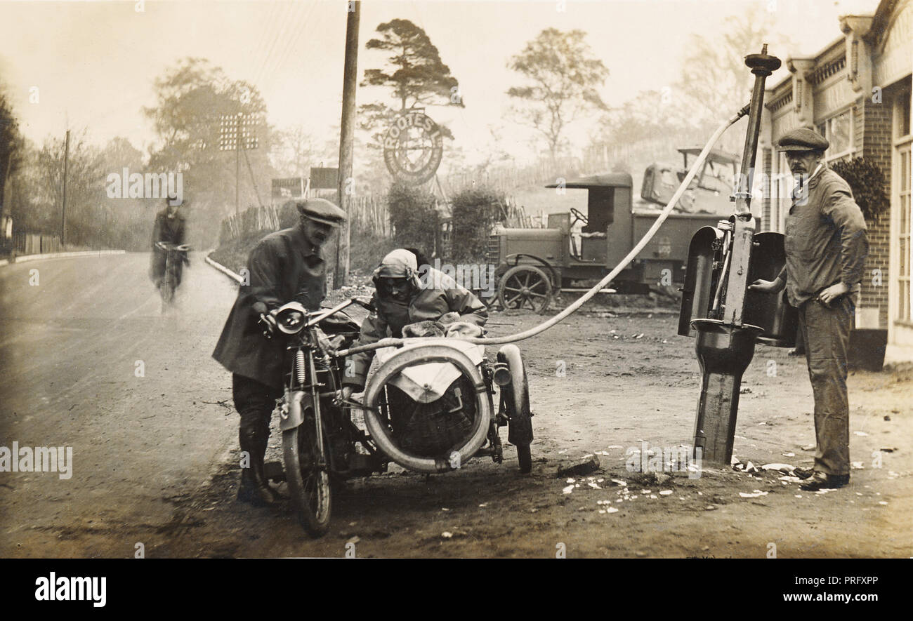 Veteran 1910 era motorcycle & sidecar combination refuelling at a garage circa 1910 Stock Photo