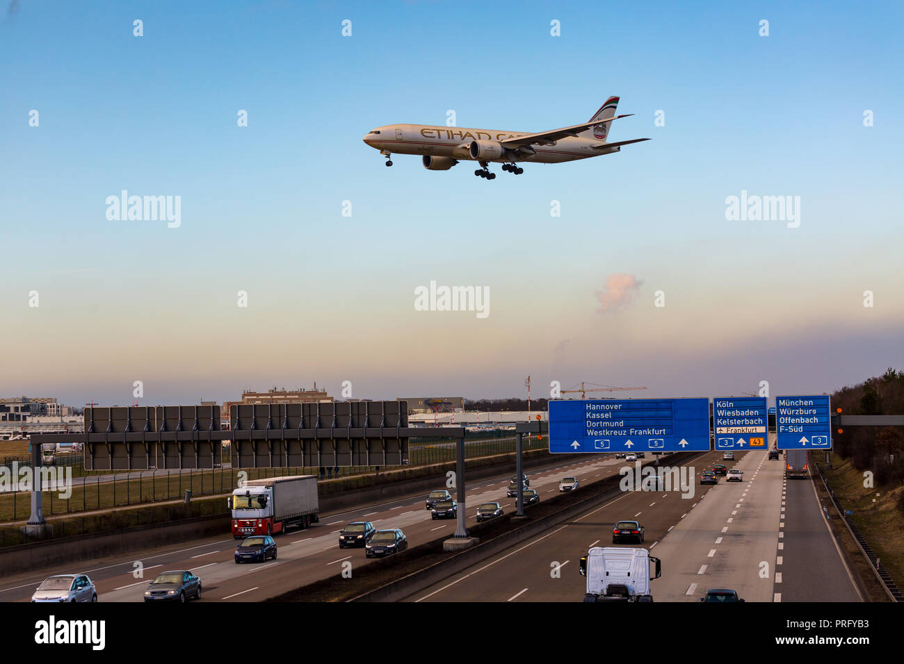 Frankfurt Airport, Germany, February 16th - 2018, Boeing 777 airplane of Etihad Airways flying over german highway autobahn A5 at Frankfurter Kreuz wh Stock Photo