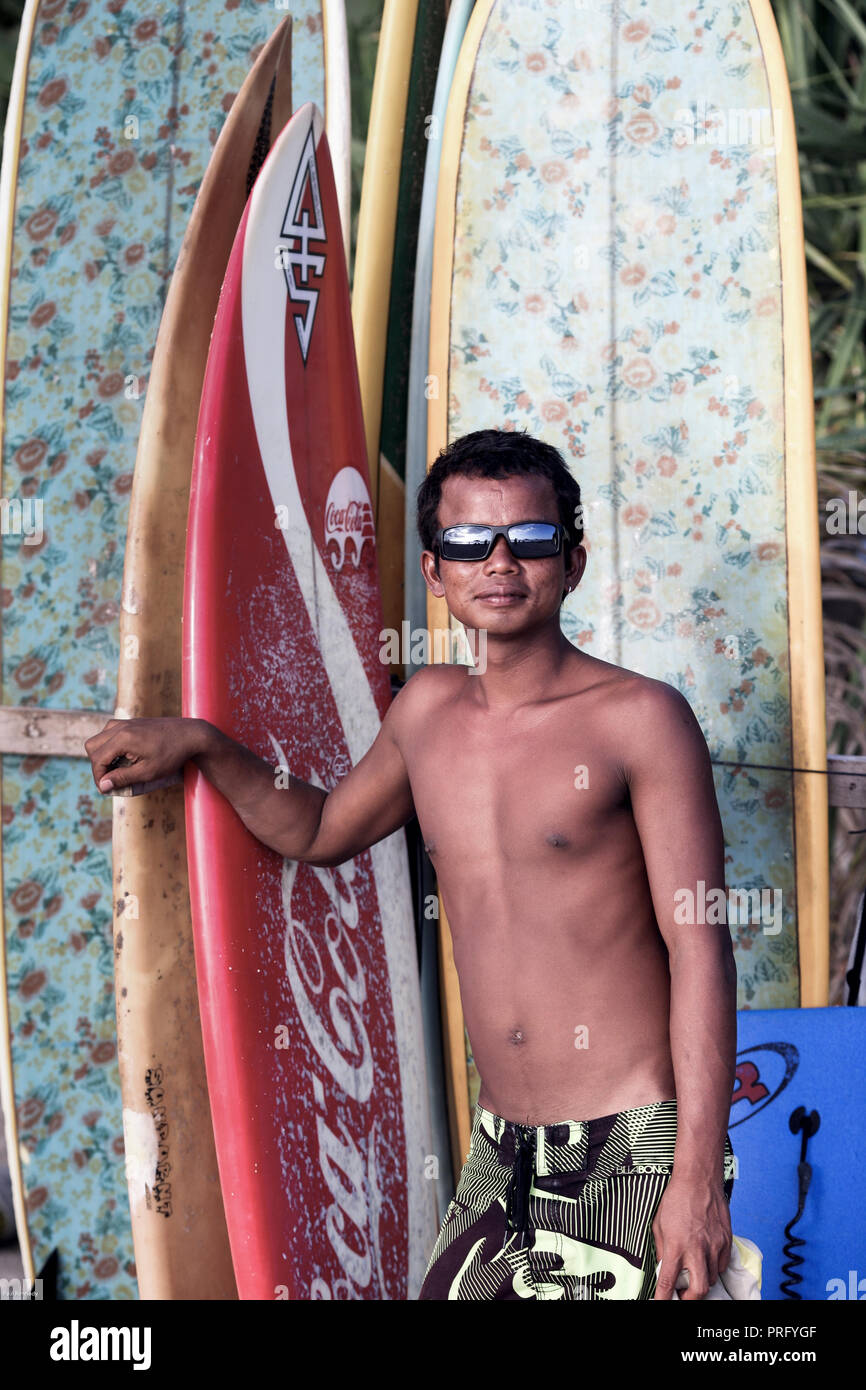 Portrait of young Balinese man renting surfboards on Kuta Beach, Bali