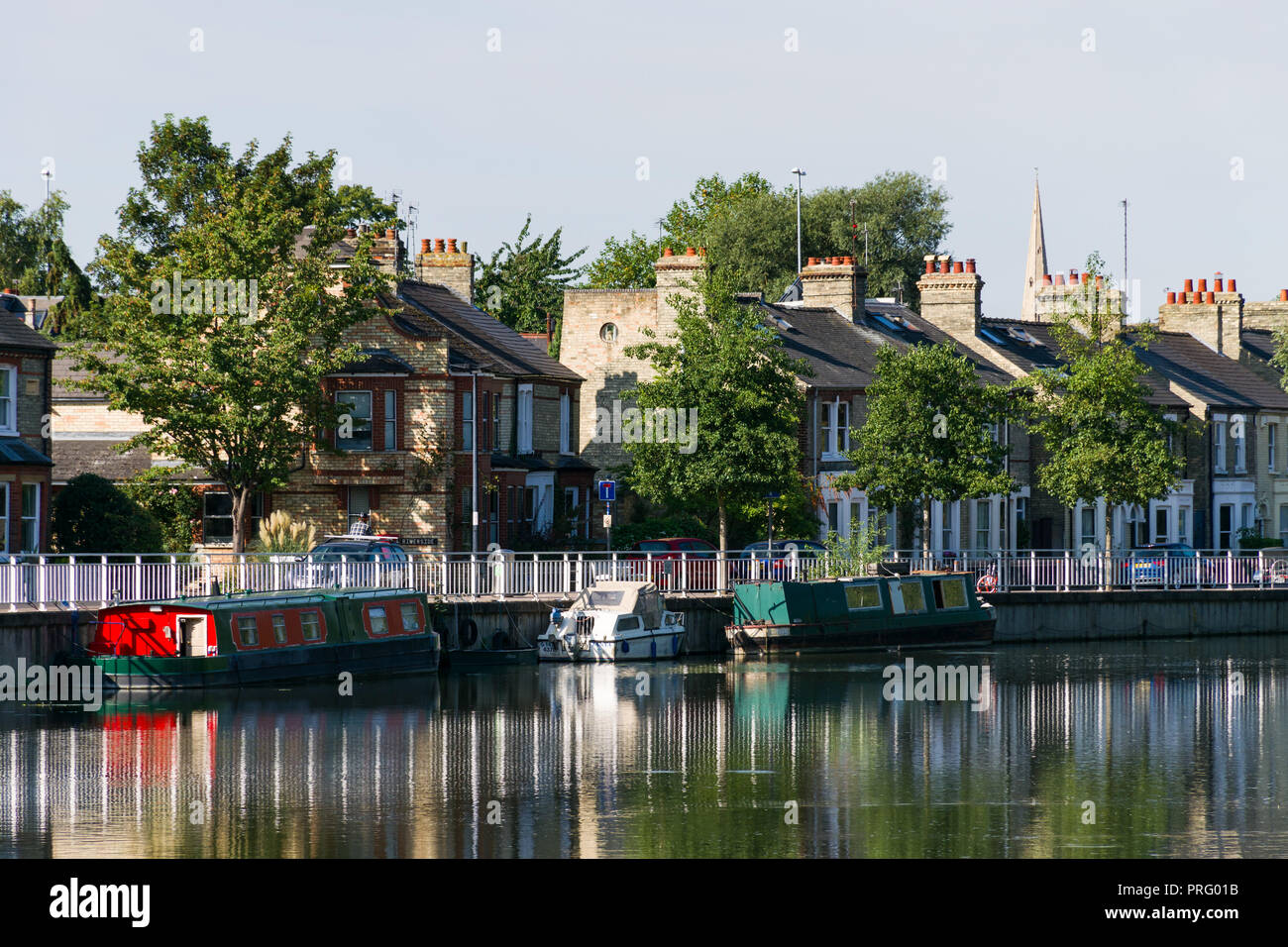 A row of houses situated by the River Cam with narrowboats moored on the river on a sunny Summer day, Cambridge, UK Stock Photo