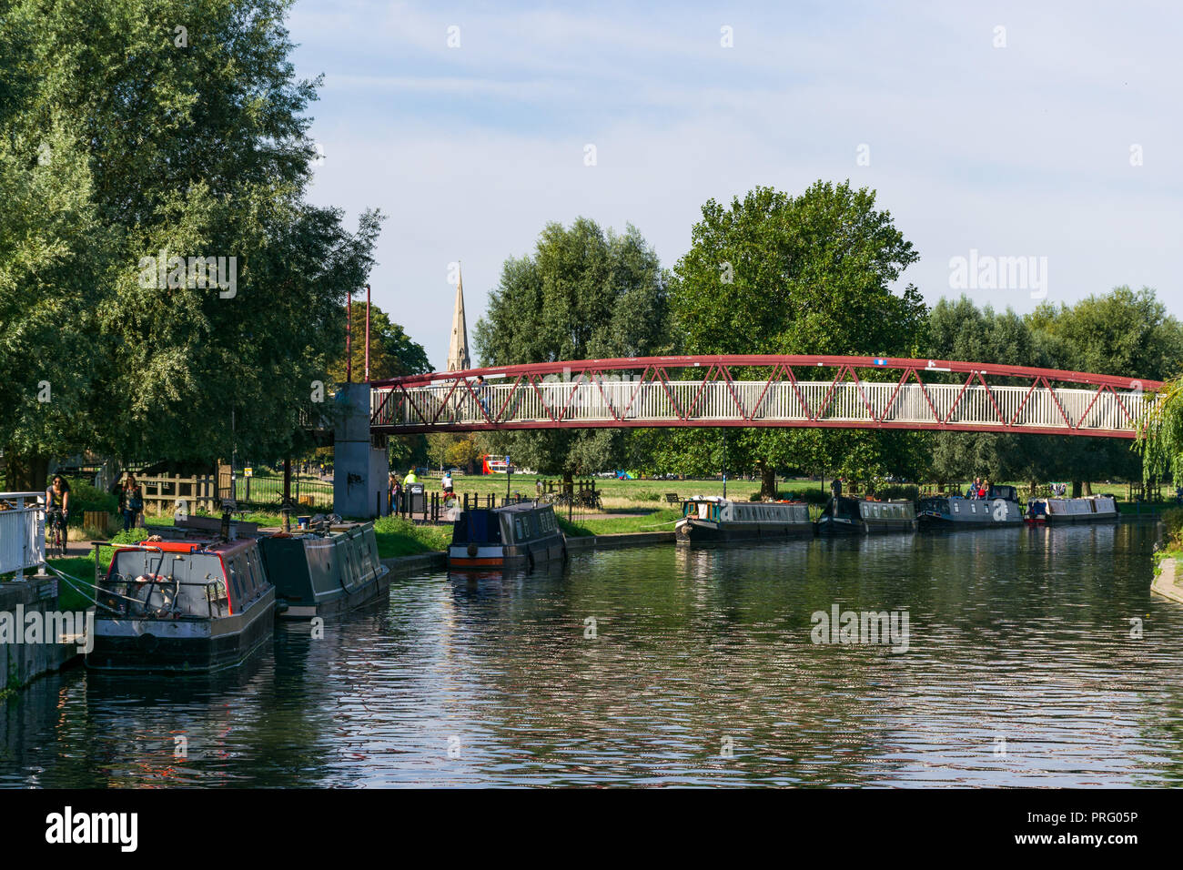 View of the river Cam and moored narrowboats with footbridge by Midsummer Common, Cambridge, UK Stock Photo