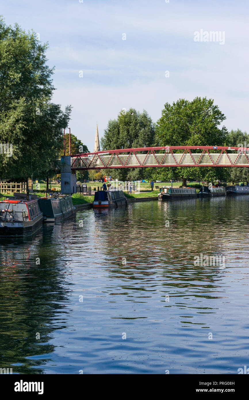 View of the river Cam and moored narrowboats with footbridge by Midsummer Common, Cambridge, UK Stock Photo