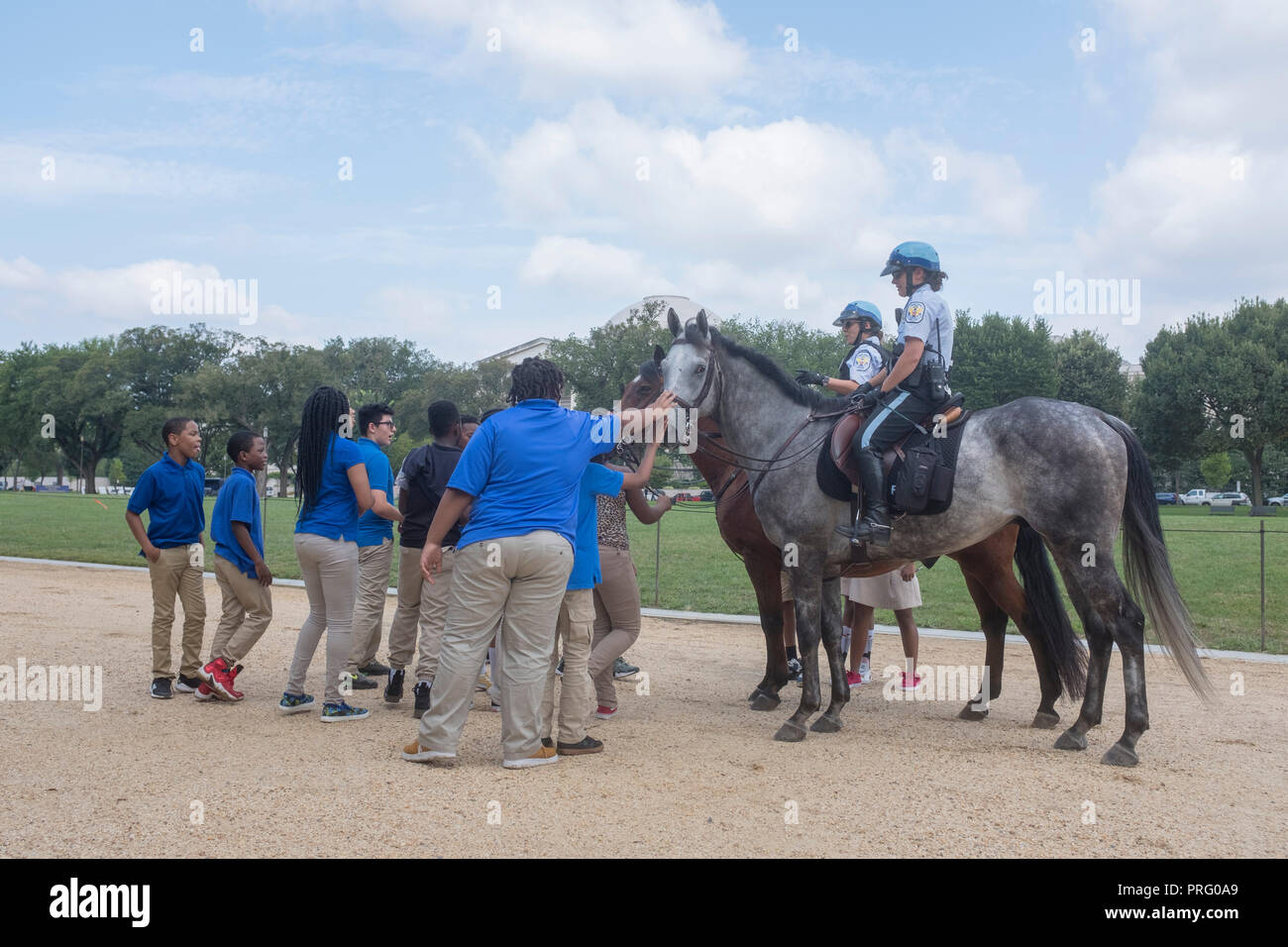 Students in matching shirts chat with mounted U.S. Park Police on the National Mall in Washington, DC. Stock Photo