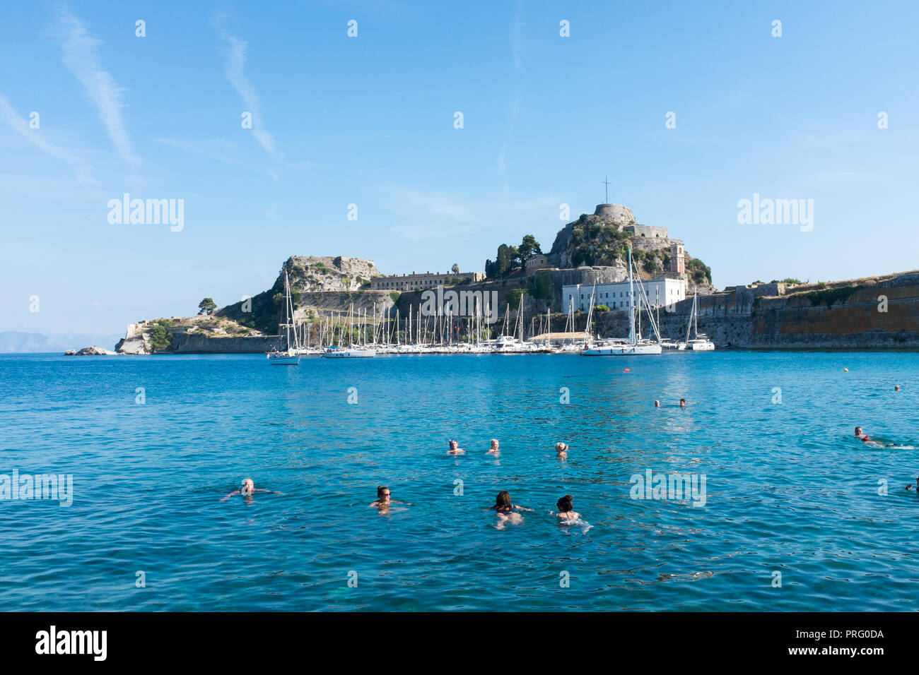 People swimming in the sea near to the Old Venetian Fort in Corfu Town, Corfu, Greece Stock Photo