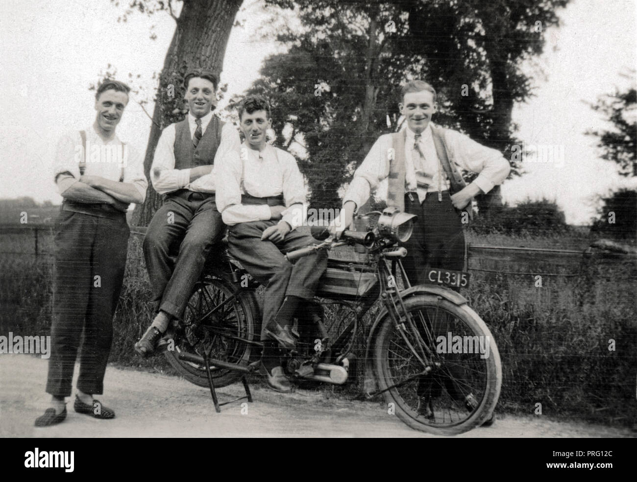Four young men posing for a photograph with a 1914/15 Triumph 500cc Model H side valve motorcycle circa 1915 Stock Photo