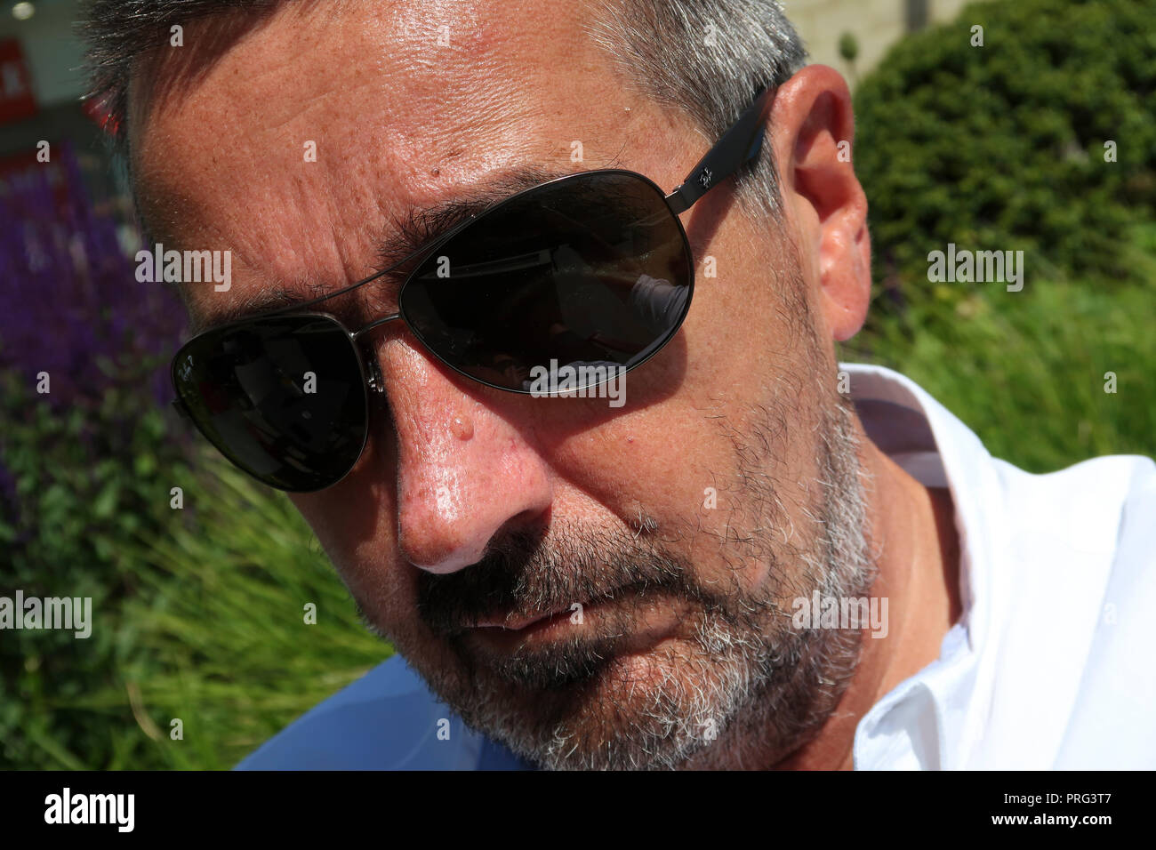 portrait of middle aged man's face with sunglasses and stubble Stock Photo