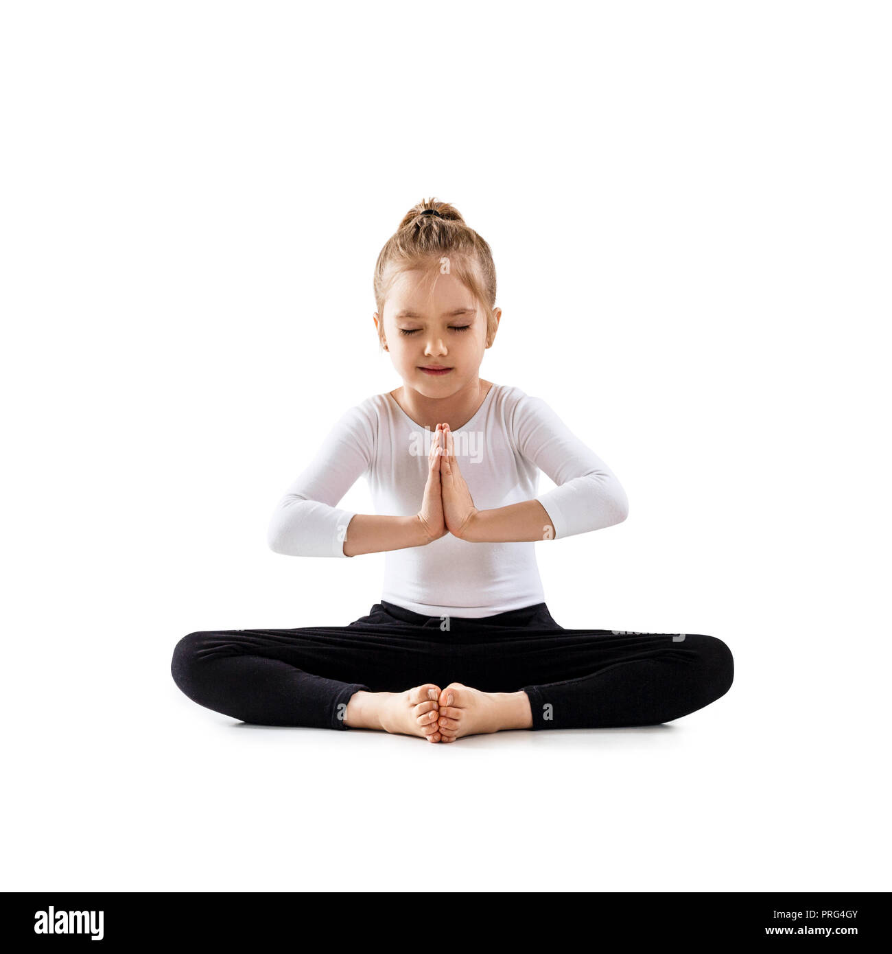 Cute little girl meditating in lotus position Stock Photo