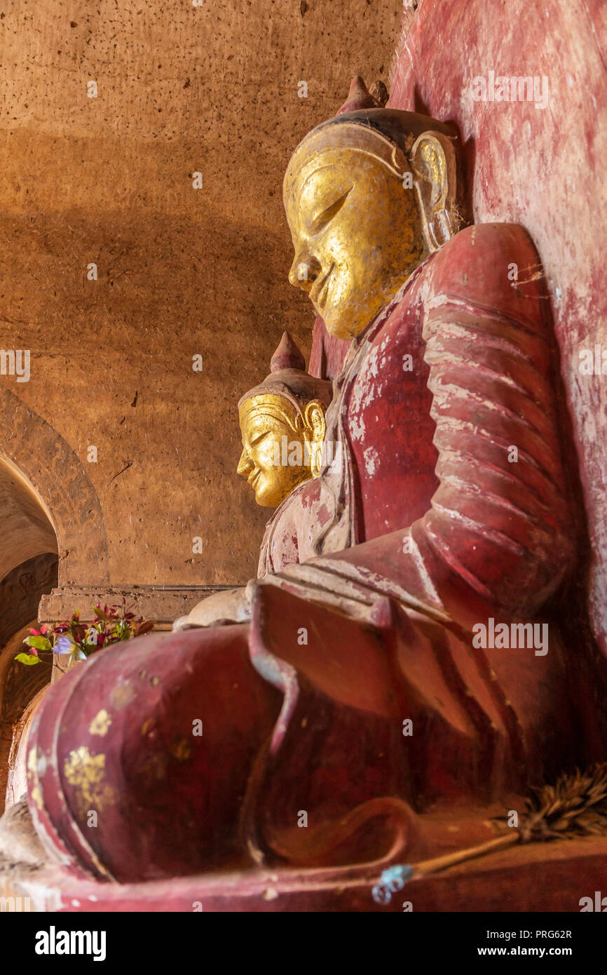Two Buddha statues in Bagan with golden head and red clothes Stock Photo Alamy