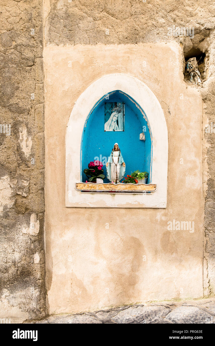 Virgin Mary shrine in a crumbling wall on Procida Island, Naples, Italy Stock Photo