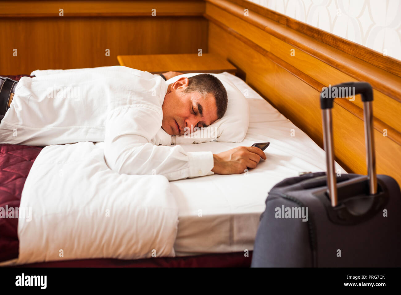 Tired businessman is sleeping on bed in hotel room Stock Photo Alamy