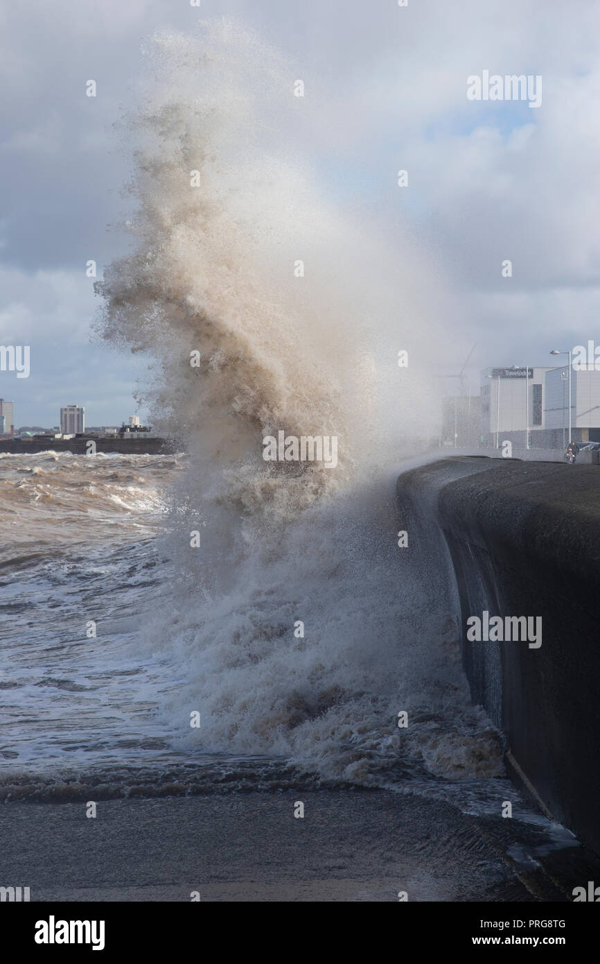 Waves from high tides crash over the promenade at New Brighton on The