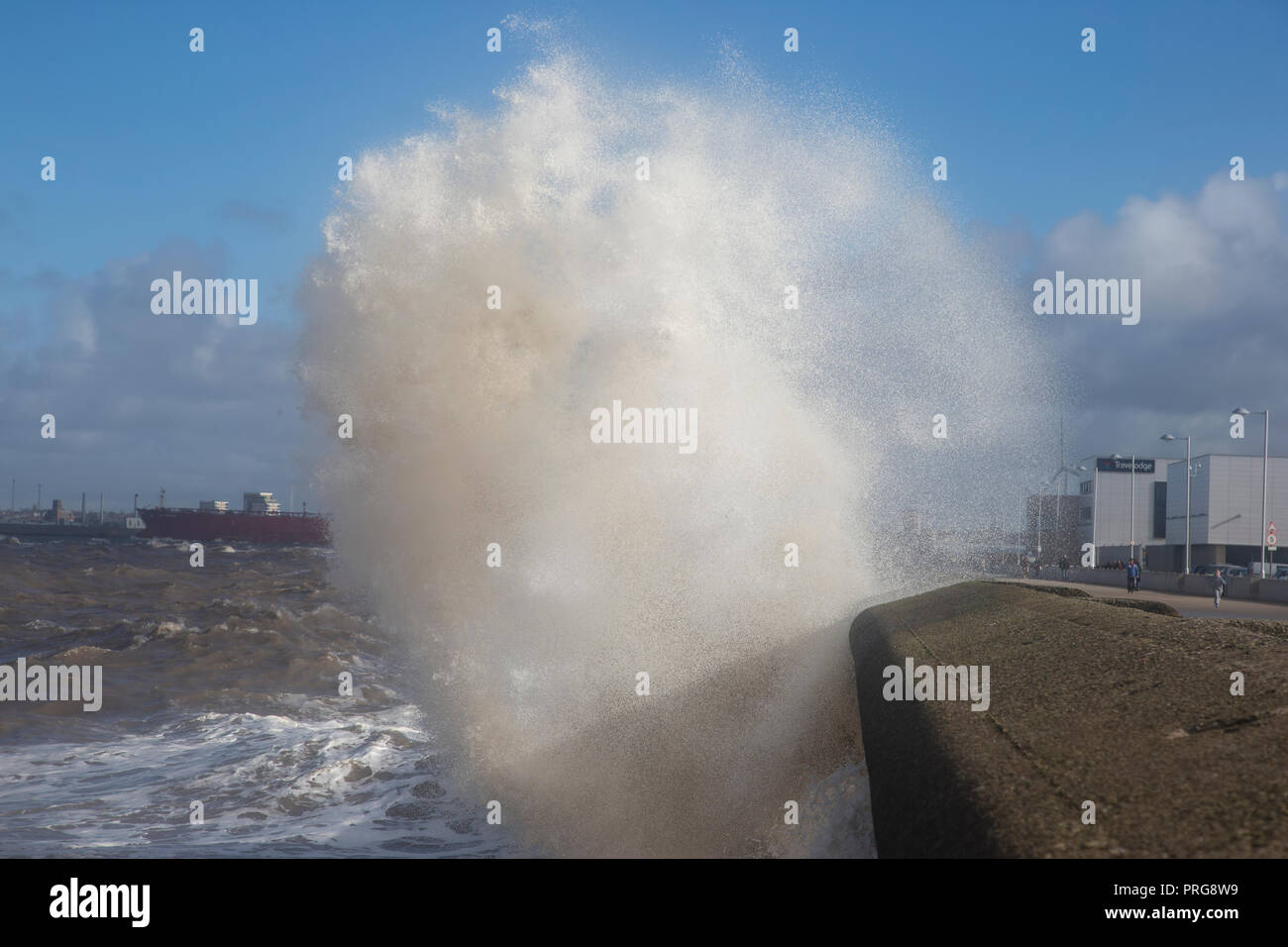 Waves from high tides crash over the promenade at New Brighton on The