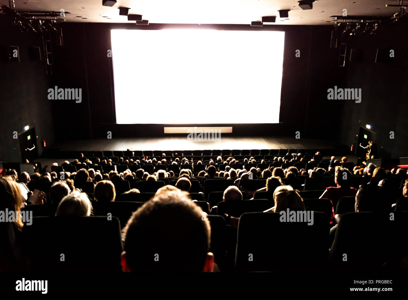 People at the Cinema Watching a Movie in Switzerland. Stock Photo