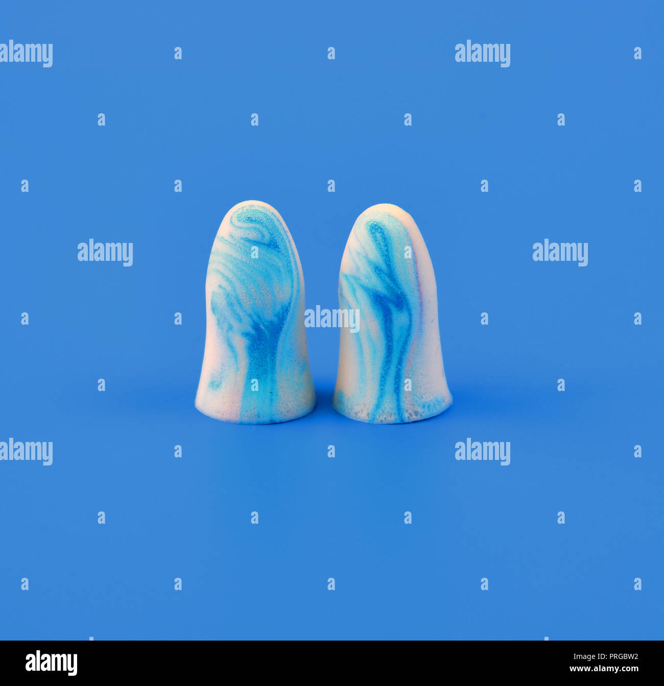two earplugs on a blue background Stock Photo
