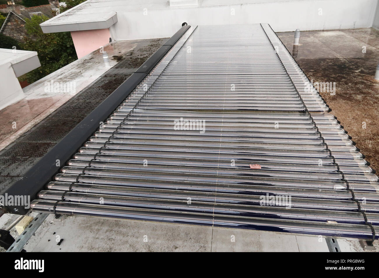 Solar water heating tubes on building roof Stock Photo