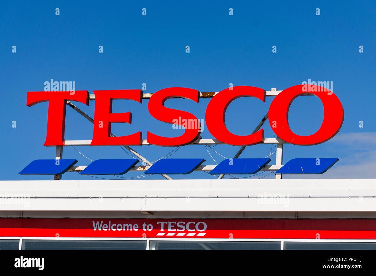 Large TESCO sign above superstore on a sunny day against blue sky, Cambridge, UK Stock Photo