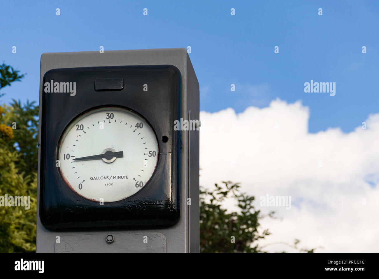 The front dial face of a large meter showing gallons per minute indicators Stock Photo